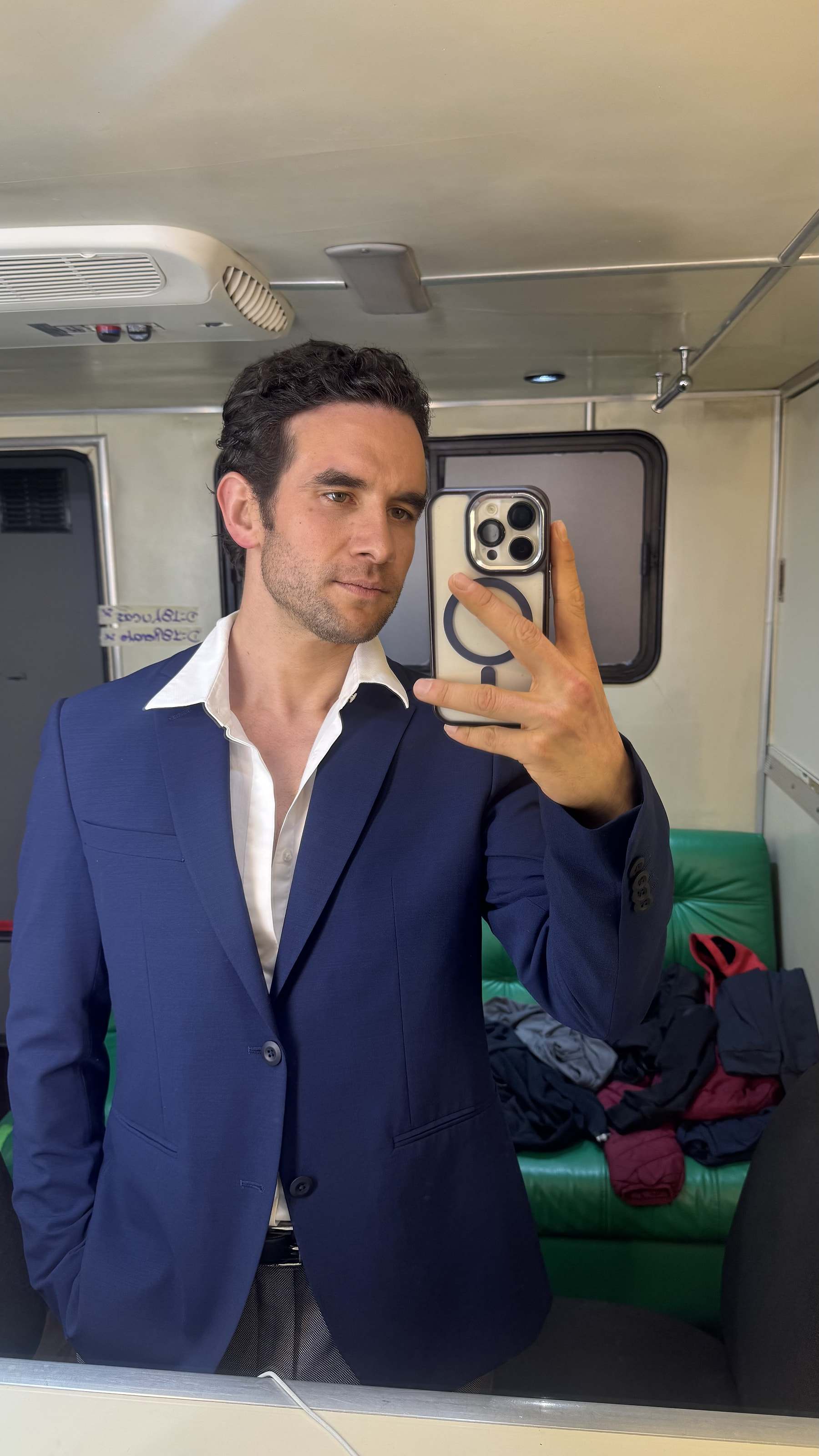 Marco Valdés con saco azul frente al espejo de un camerino