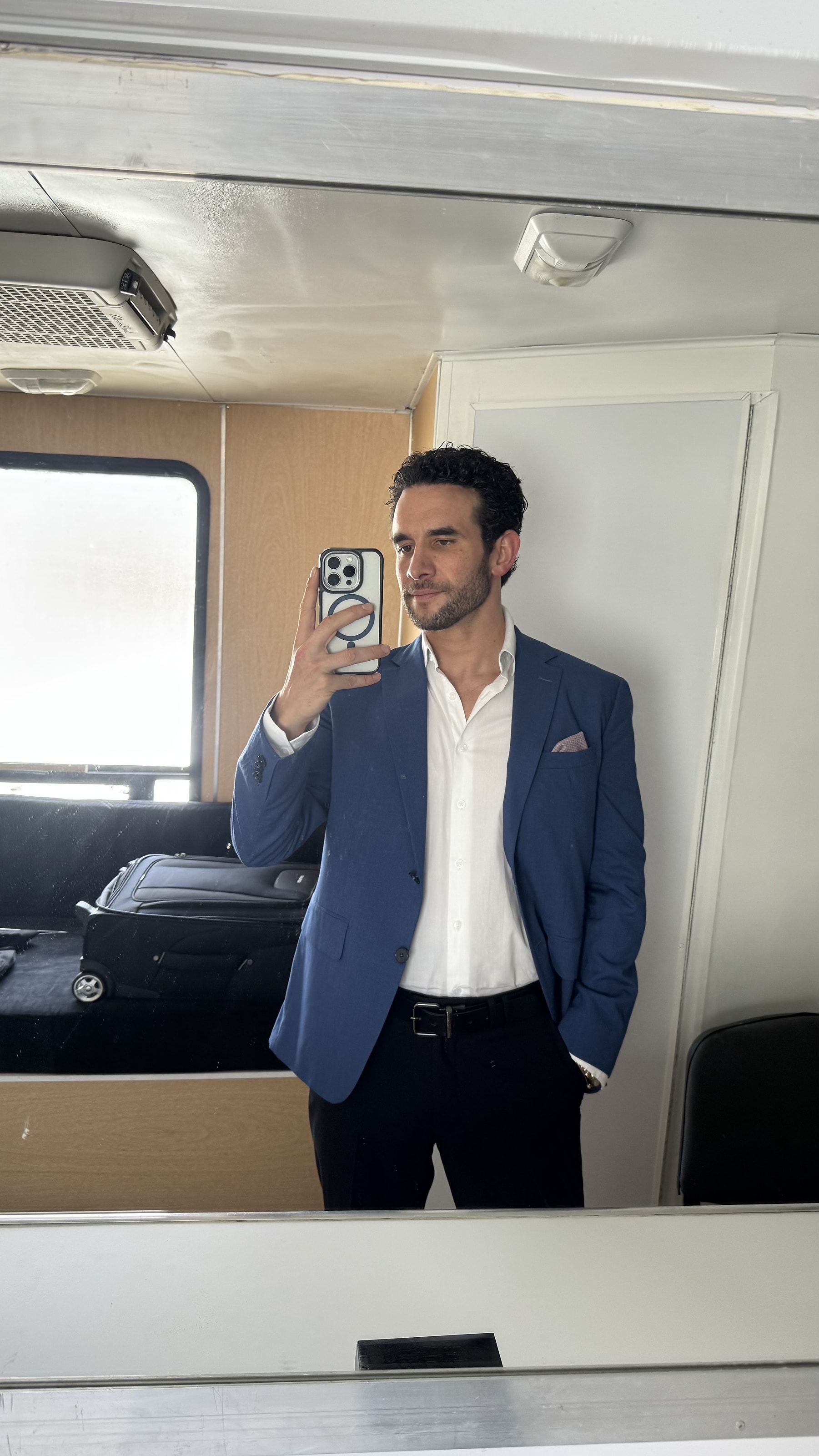 Marco Valdés con saco azul frente al espejo de un camerino